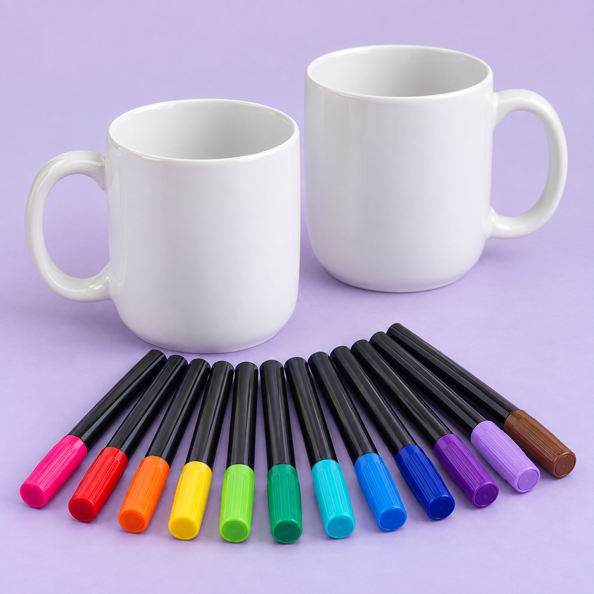 Two blank ceramic mugs and twelve porcelain markers